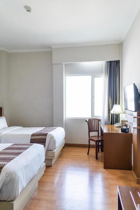 Image de la chambre d'hotel montrant deux lits et une fenetre