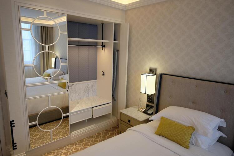 Image de la chambre d'hotel montrant un lit et une armoire