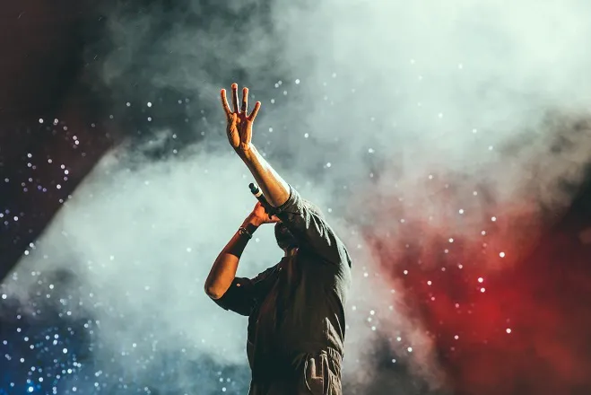Photo d'un chanteur entouré de fumée pendant un concert